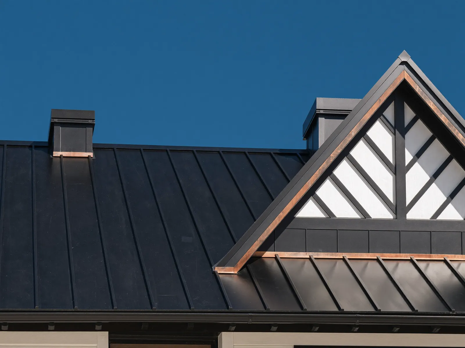 Standing-seam metal roof detail with copper trim